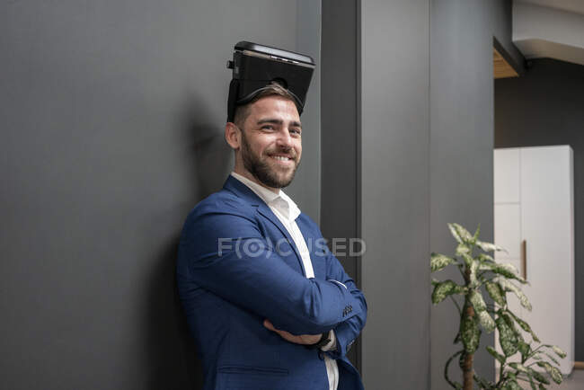 Впевнений бізнесмен з шолом віртуального моделювання стоїть у творчому кабінеті — стокове фото