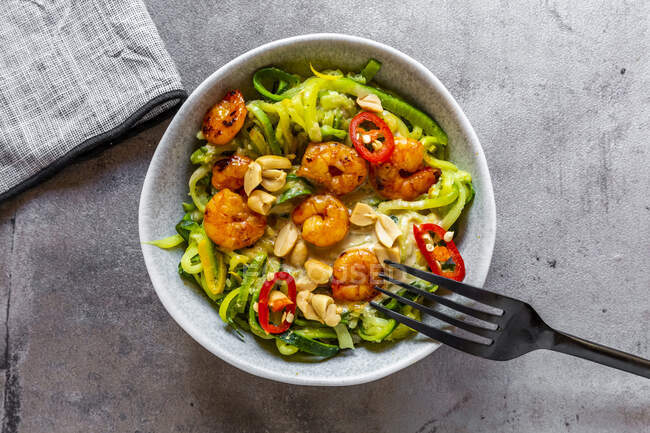 Close-up of zoodles with shrimps and chili served in bowl on table — Stock Photo