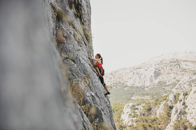 Scalatore di roccia femminile scalatore montagna contro cielo limpido — Foto stock