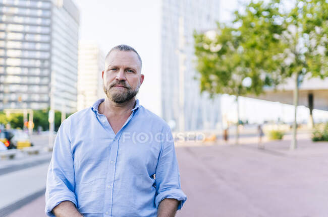 Зрелый предприниматель-мужчина стоит на тропинке в городе — стоковое фото