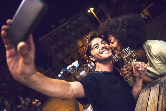 Frau küsst Freund mit Selfie bei Date-Nacht — Stockfoto