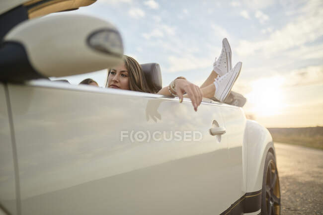 Низька частина жінки з друзями відпочиває, сидячи в конвертованій машині. — стокове фото