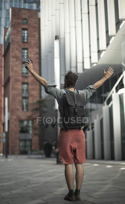 Homme debout les bras tendus dans la rue en ville — Photo de stock