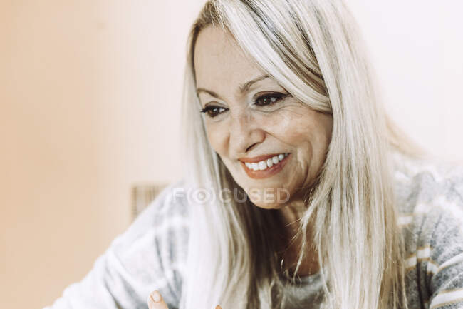 Sorrindo mulher idosa contra parede em casa — Fotografia de Stock