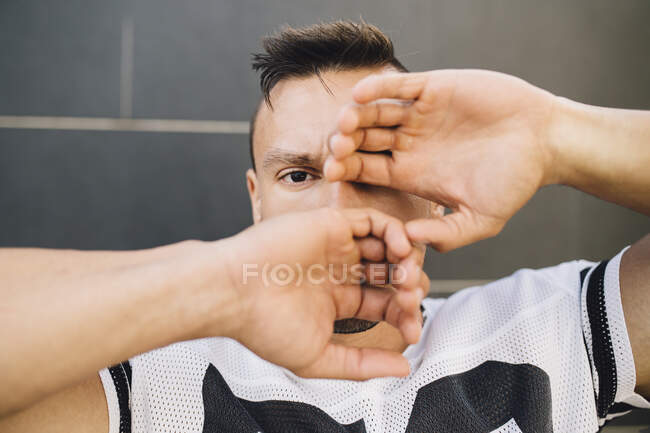 Gros plan du jeune homme avec les mains couvrant le visage contre le mur — Photo de stock