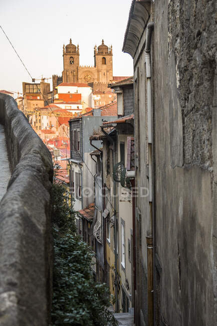 Portugal, Porto District, Porto, Alley stretching along old townhouses with Porto Cathedral in background — Stock Photo