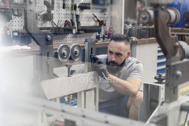 Ingénieur masculin professionnel se concentrant tout en examinant la machine dans l'industrie — Photo de stock