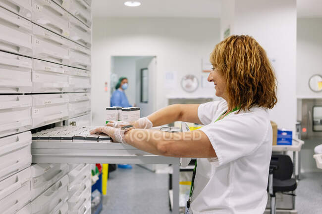 Médico feminino organizando medicamentos na gaveta na sala de armazenamento — Fotografia de Stock