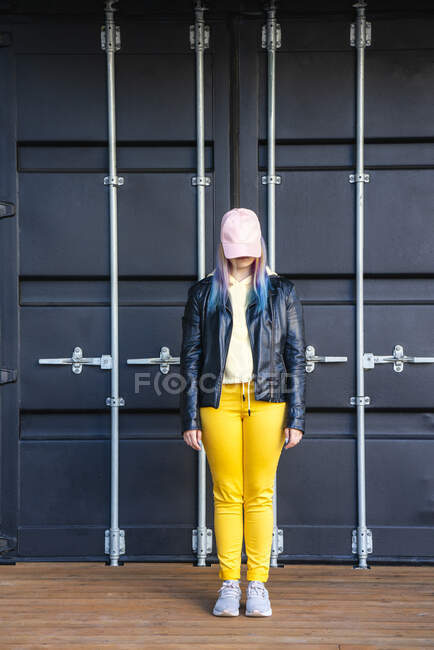 Portrait of young woman with dyed hair in front of black container — Foto stock