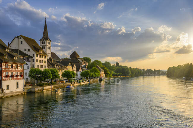 Switzerland, Canton of Thurgau, Diessenhofen, High Rhine and adjacent village at cloudy sunset — Stock Photo