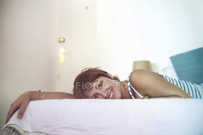 Усмішка молодої жінки лежить на ліжку. — стокове фото