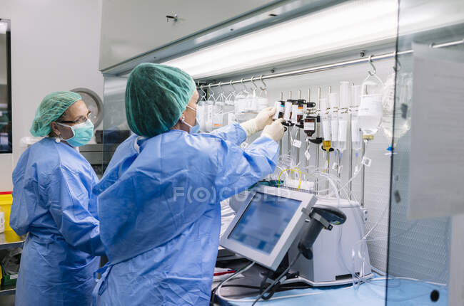 Female pharmacists arranging drips on rack at laboratory in hospital — Stock Photo