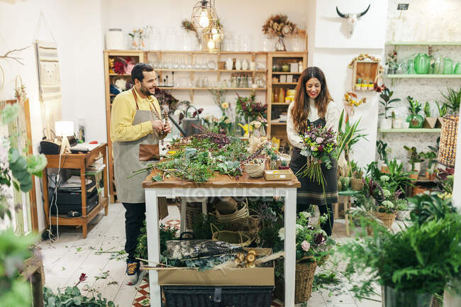 Uomo e donna che lavorano in piedi al negozio di fiori — Foto stock