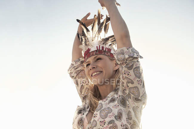 Весела молода жінка танцює проти ясного неба на пляжі в сонячний день. — стокове фото