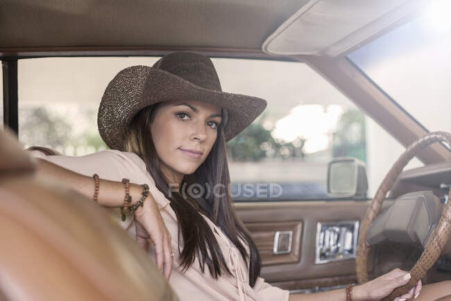 Confident woman wearing hat sitting in car — Stock Photo
