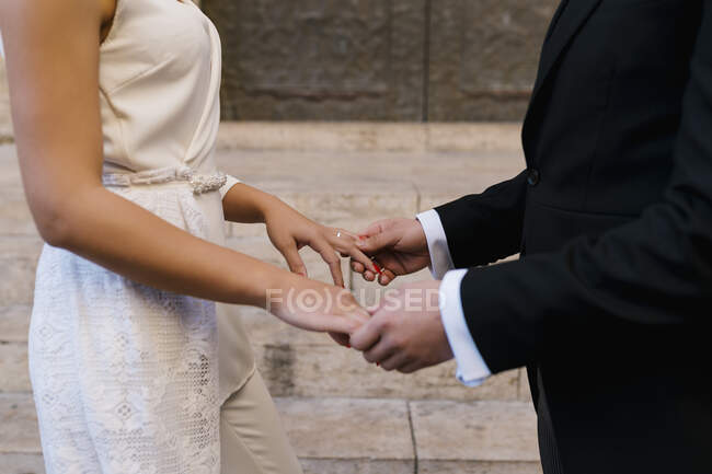 Giovane coppia sposata che si tiene per mano dalla chiesa — Foto stock