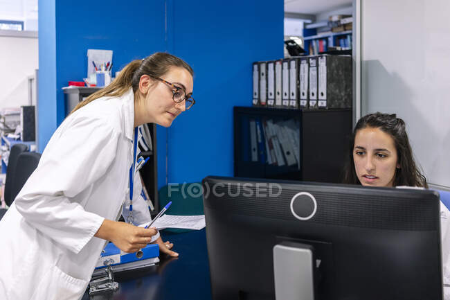Colleghi che discutono di computer sulla scrivania in ospedale — Foto stock