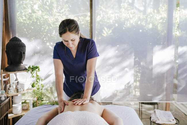 Mid Adult Woman Giving Back Massage To Female Customer Lying On Table In Spa — Hands Standing