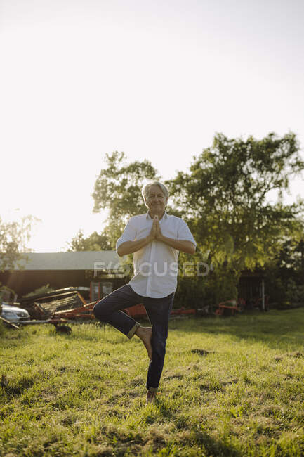 Man doing yoga on one leg against clear sky in yard — Stock Photo