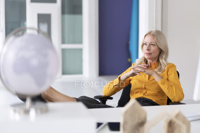 Ragionevole donna d'affari con le mani strette seduta sulla sedia in home office — Foto stock