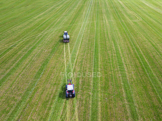 Vista aérea de dois tratores coletando fardos de feno no campo — Fotografia de Stock