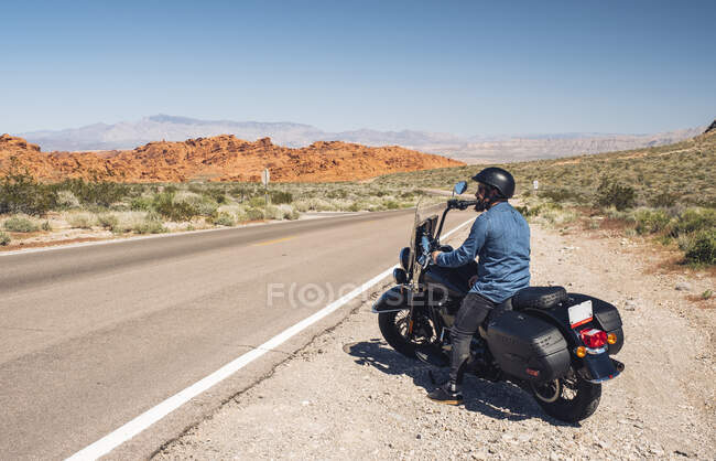 Человек на мотоцикле во время поездки по дороге летом, Невада, США — стоковое фото