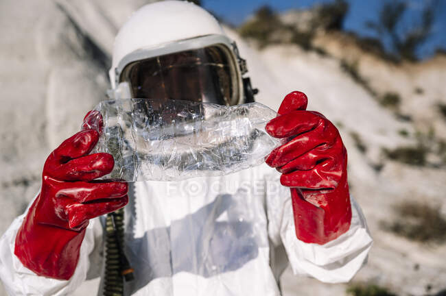 Close-up of male astronaut holding plastic bottle while standing on other planet — Stock Photo