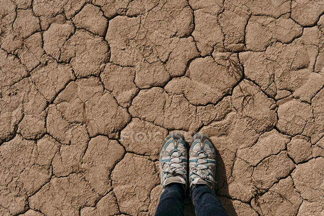 Spain, Navarre, Shoes of woman standing on dry cracked ground of Bardenas Reales — Stock Photo