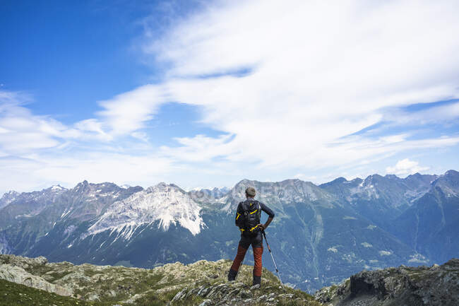 Caminhante em pé no topo do pico enquanto olha para as montanhas, Western Rhaetian Alps, Sondrio, Itália — Fotografia de Stock