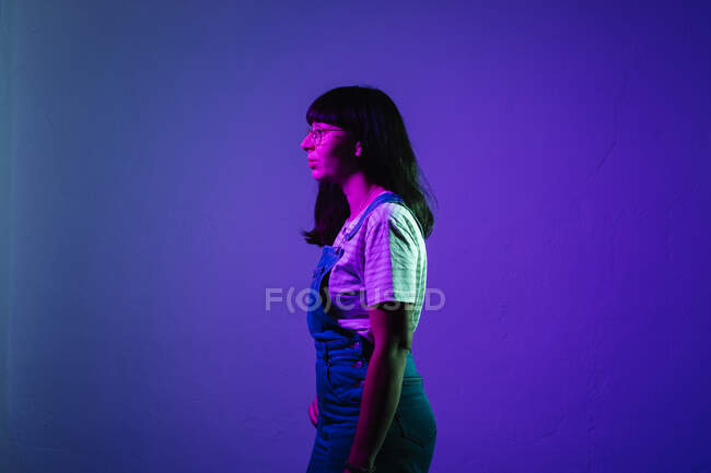 Young woman standing against colored background — Stock Photo