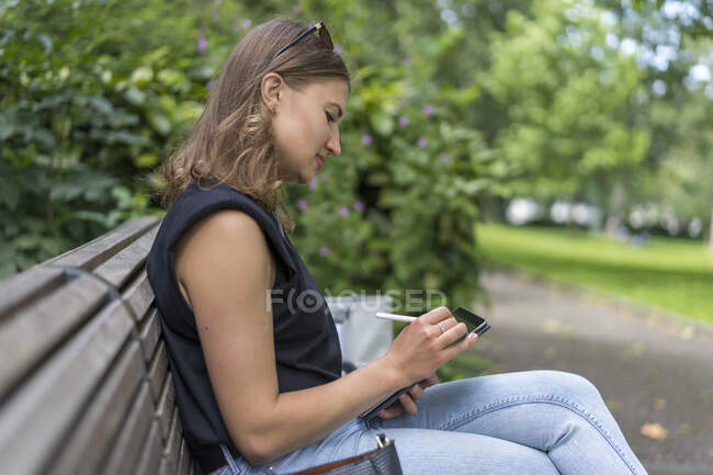 Junge Frau zeichnet im öffentlichen Park auf Grafik-Tablet — Stockfoto