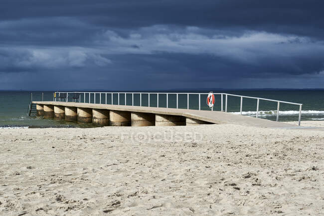 Jetty vazio na praia contra o céu nublado — Fotografia de Stock