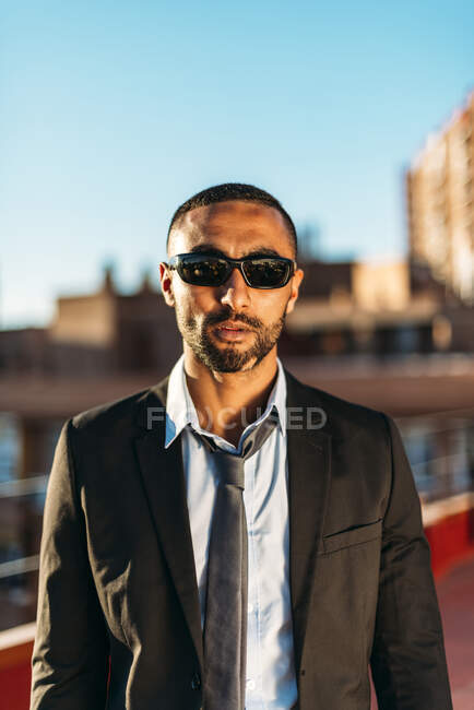 Confident businessman wearing sunglasses while standing at rooftop — Stock Photo