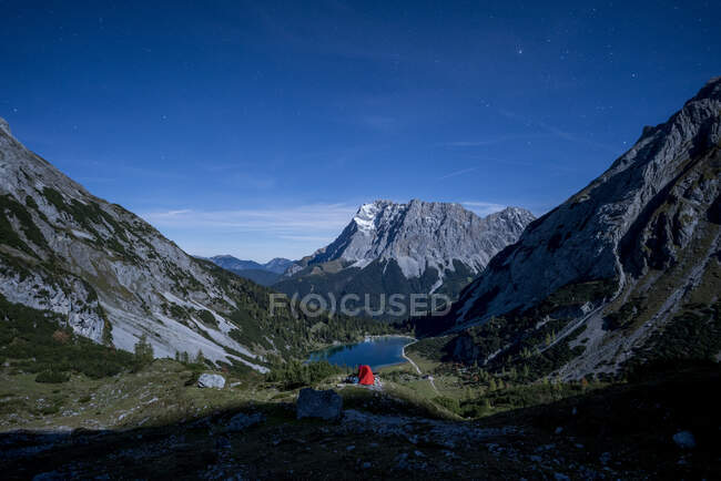 Tent pitched in mountain valley at dusk with Seebensee in background — Stock Photo