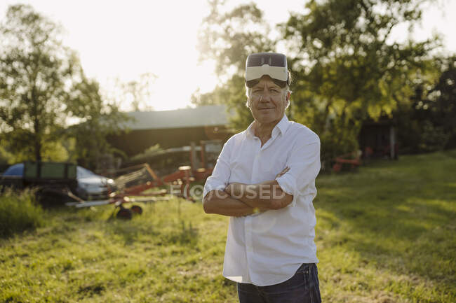 Homme aux bras croisés portant des lunettes VR dans la cour arrière — Photo de stock