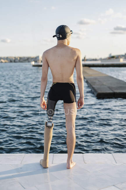 Amputato maschio guardando il mare mentre in piedi sul lungomare durante la giornata di sole — Foto stock