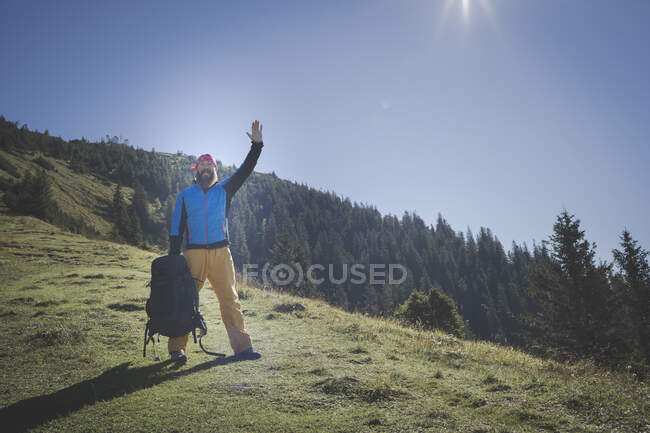 Зрелый мужчина с поднятой рукой, стоящий на горе против ясного неба, Отшер, Австрия — стоковое фото