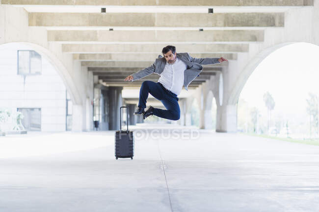 Empresário animado despreocupado pulando no caminho concreto — Fotografia de Stock