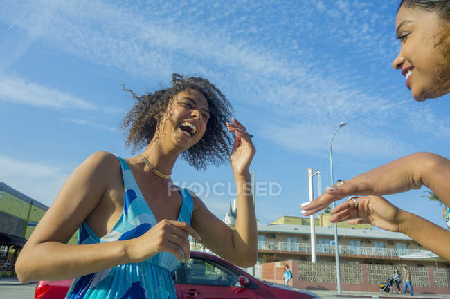 Giovane donna che ride guardando amico femminile in città nella giornata di sole — Foto stock