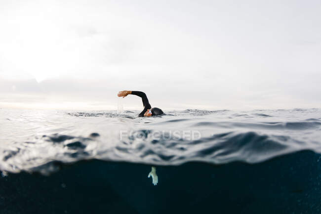 Человек плавает один в море — стоковое фото