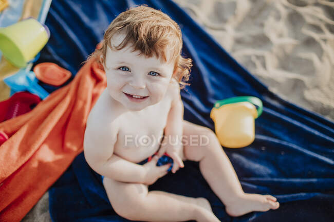 Ragazzo carino sorridente mentre gioca in spiaggia nella giornata di sole — Foto stock