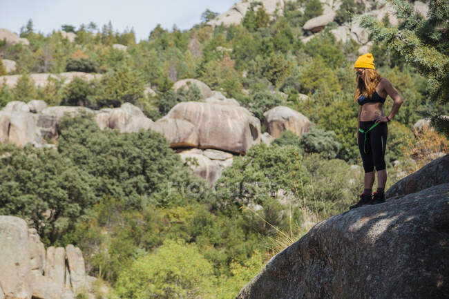 Female trekker admiring view while standing on rock in forest at La Pedriza, Madrid, Spain — Stock Photo