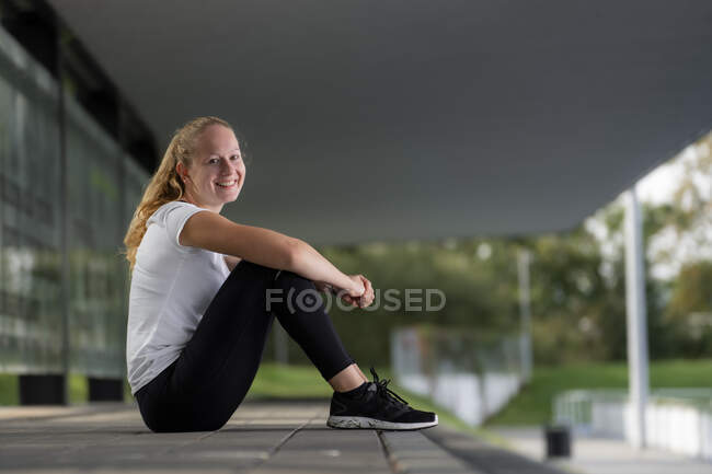 Junge Sportlerin ruht sich am Trainingsplatz aus — Stockfoto