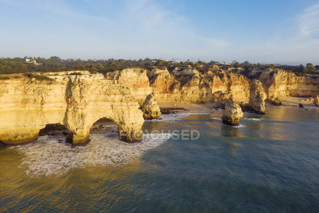 Portugal, Distrito de Faro, Drone vista de los acantilados de Praia da Marinha al amanecer - foto de stock