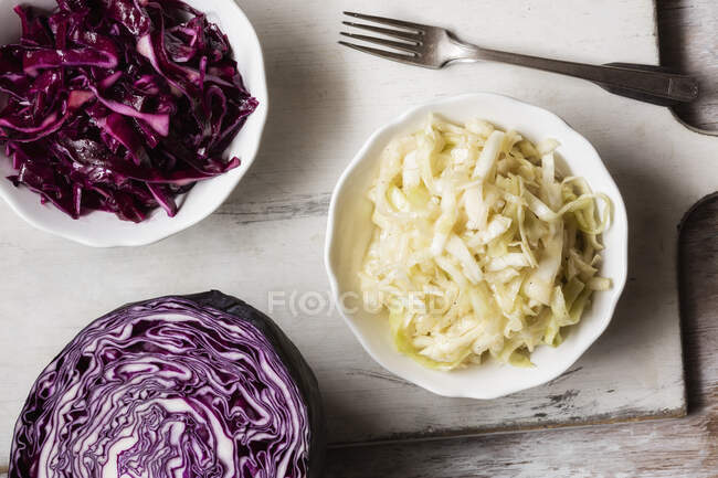 Red and white cabbage bowl by chopped red cabbage on table — Stock Photo