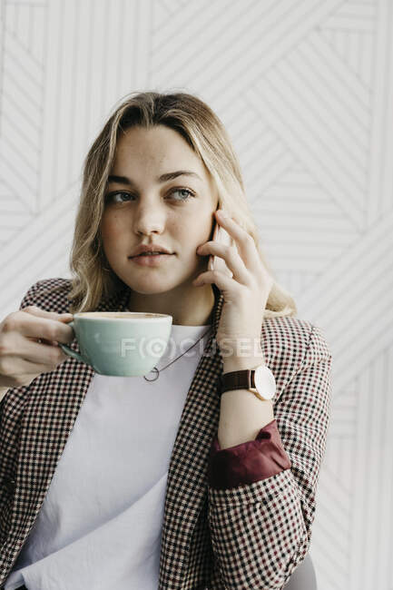 Junge Frau schaut beim Kaffeetrinken im Café weg — Stockfoto