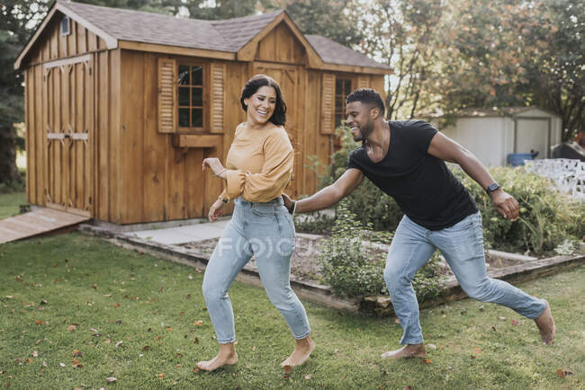 Man catching woman from behind while running at backyard — Stock Photo