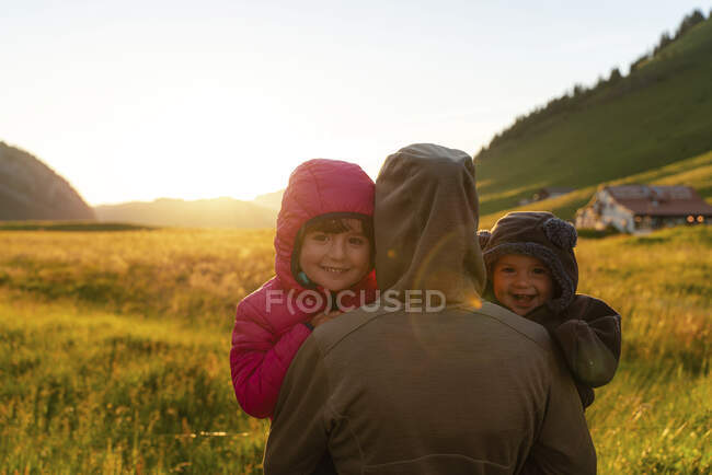 Bambini sorridenti con la madre al tramonto durante le vacanze al Col Des Aravis, Alta Savoia, Francia — Foto stock