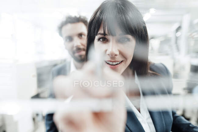 Confident businesswoman planning with male colleague at industry — Stock Photo