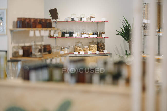 Interior de la cafetería con frascos de vidrio dispuestos en el estante - foto de stock